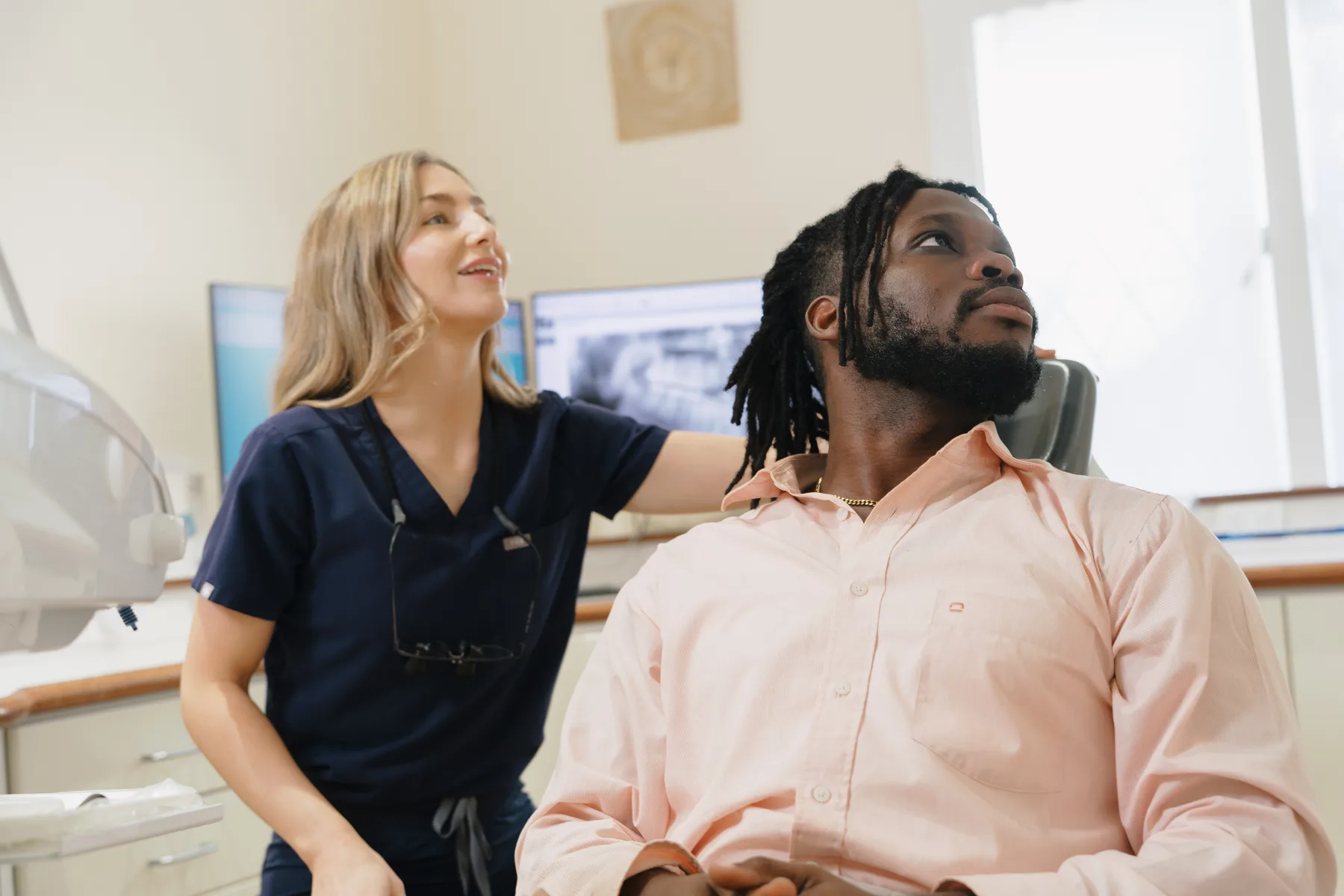 A dentist talking with a patient in the treatment room