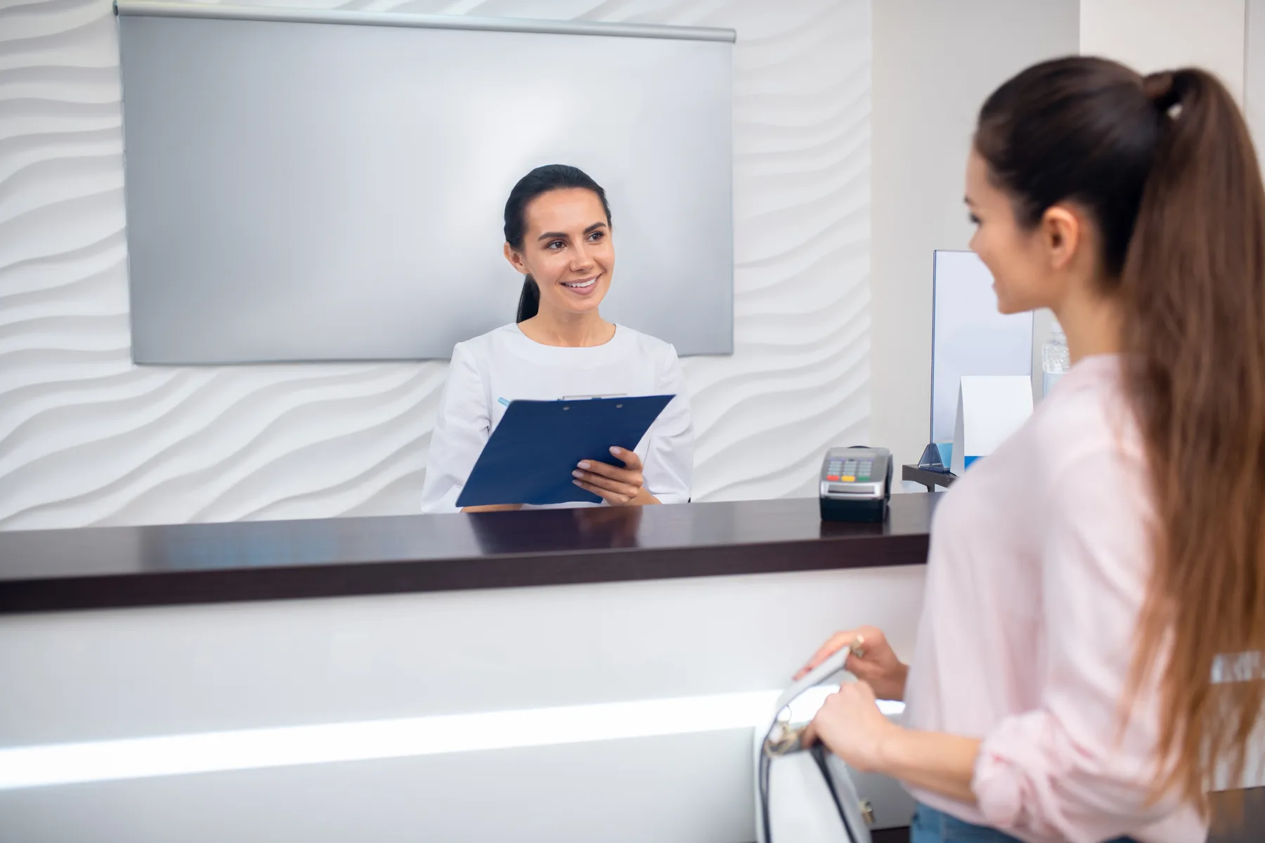 A patient and team member at a dental reception
