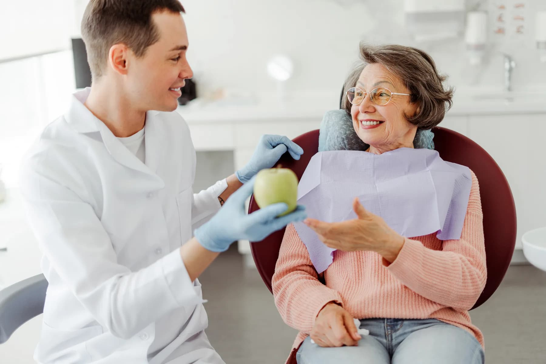 A dentist explaining a tooth model to a patient
