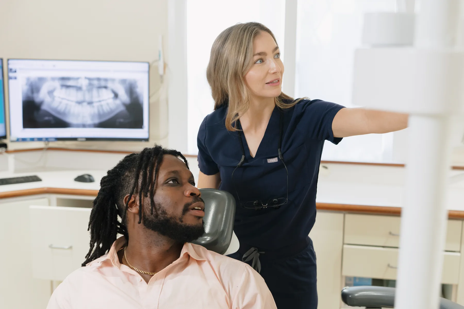 A dentist explaining dental images to a patient