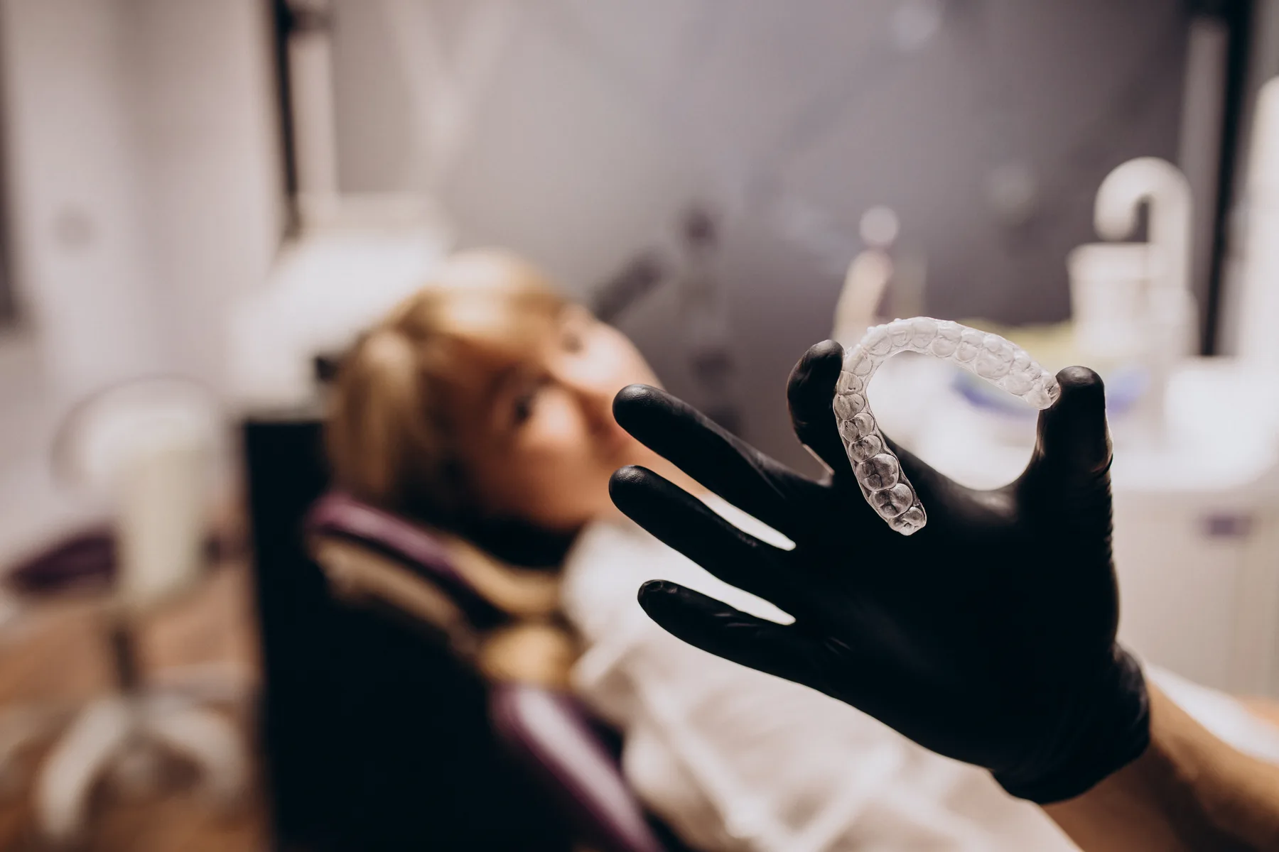 A clinician holding a clear aligner