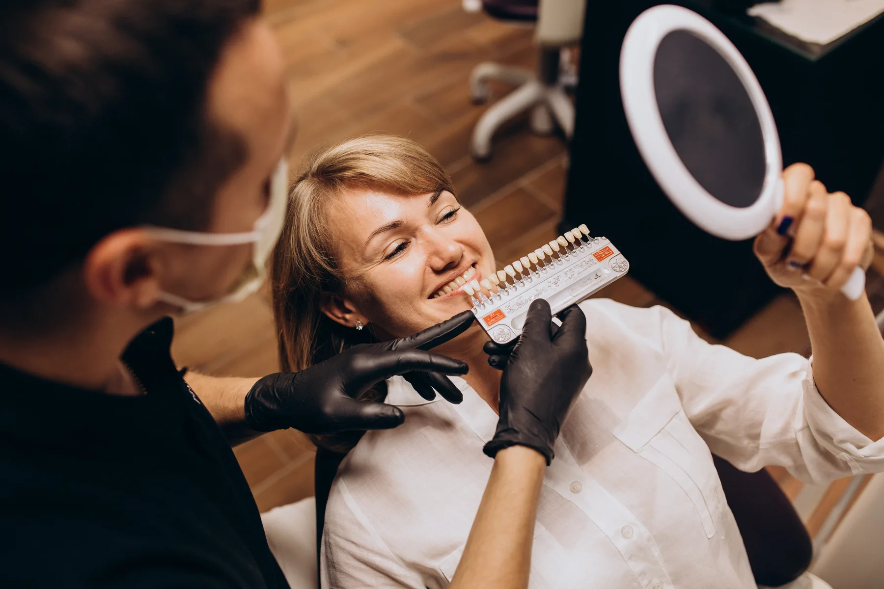 A patient comparing tooth shades during a consultation