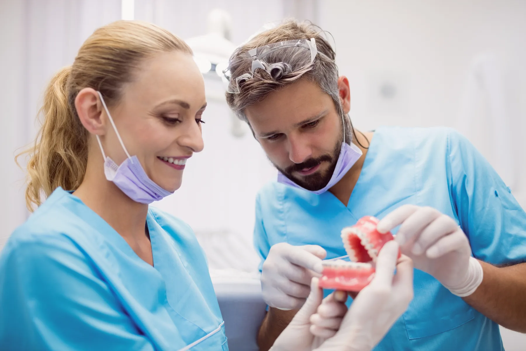 A dental professional explaining a tooth model