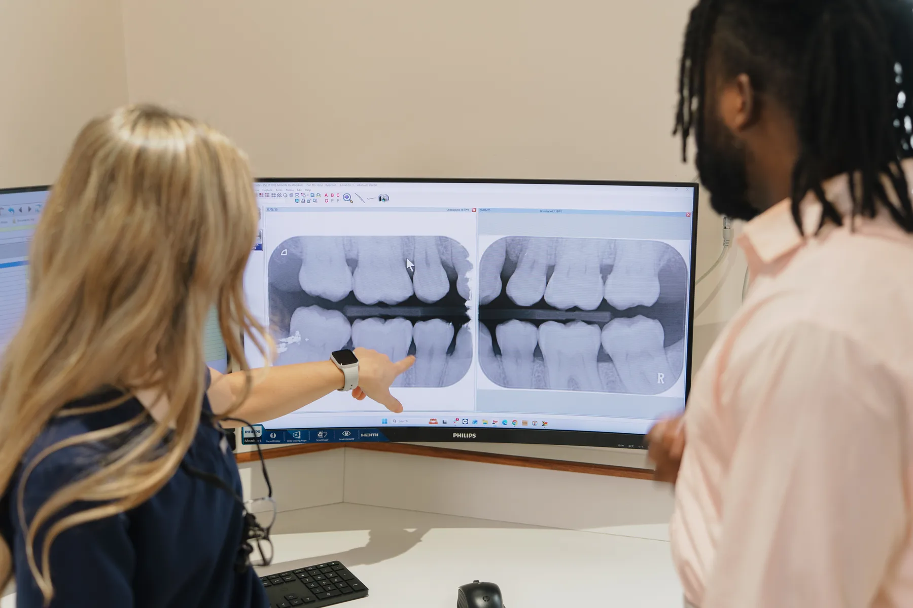 A dentist reviewing dental images with a patient